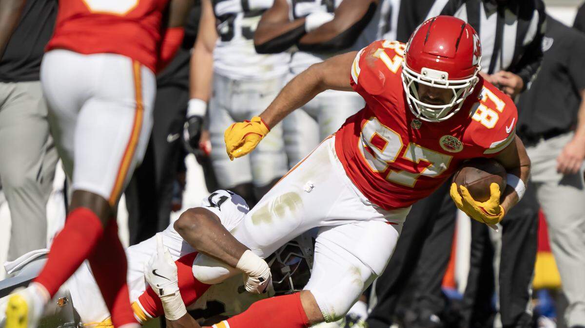 Kansas City Chiefs tight end Travis Kelce (87) carries the ball as he is tackled by Las Vegas Raiders safety Jeremy Chinn (11) during the second half on Sunday, October 19, 2025, at GEHA Field at Arrowhead Stadium in Kansas City. The Chiefs defeated the Raiders, 31-0.