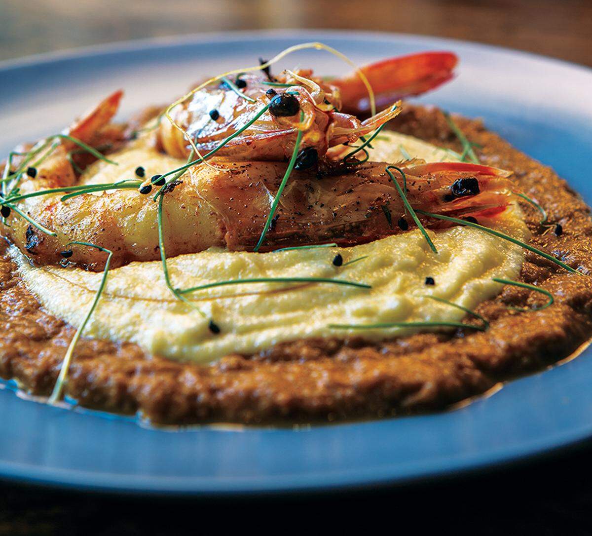 Banksia’s oversized Australian prawns are flavored with bacon and sage and served shrimp and grits-style on a bed of polenta.