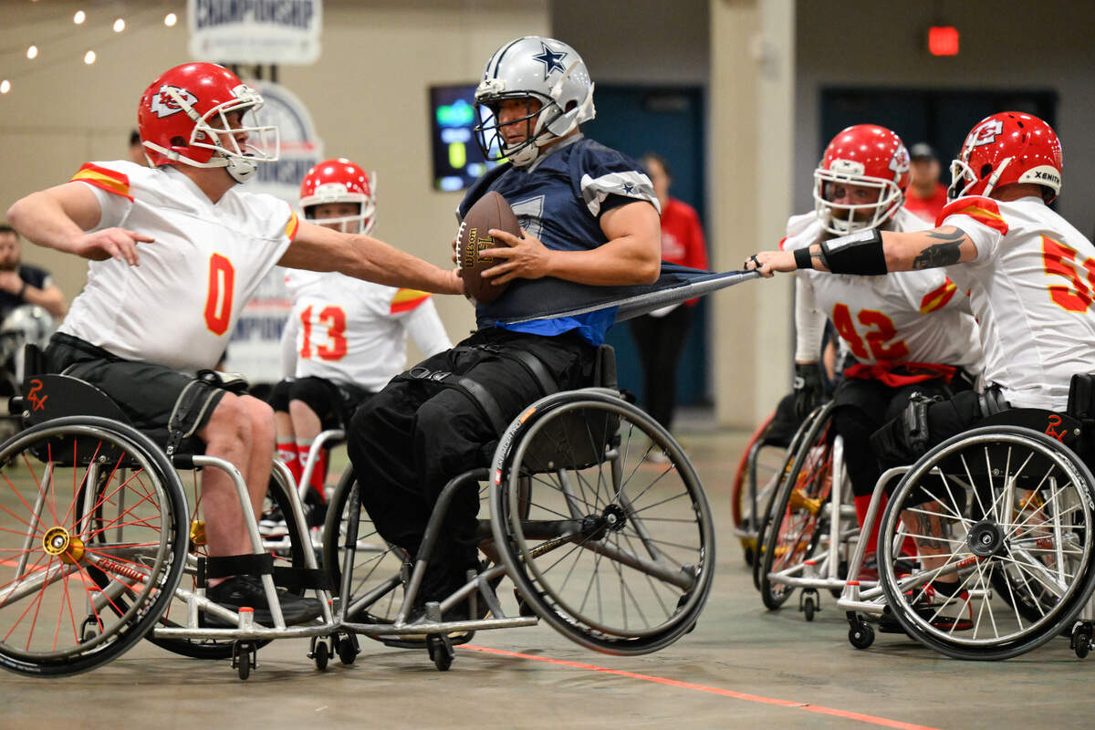 Dallas Cowboys player Jason Rainey (7) is tackled by Kansas City Chiefs player Clayton Peters (0) and Kansas City Chiefs player Jason Lofts (58) during the USA Wheelchair Football League Championship, a program of Move United, Tuesday, Feb. 6, 2024 in Dallas, Texas.