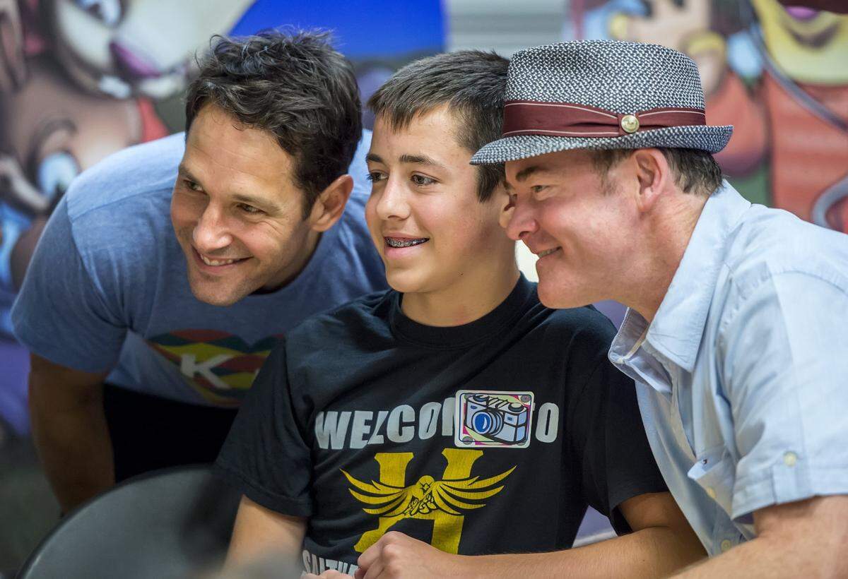 Paul Rudd, left, and David Koechner, right, posed for a photograph with Austin Hedges, 14, center, during a media event with Childen’s Mercy Hospital patients promoting the Big Slick fundraiser in 2014.