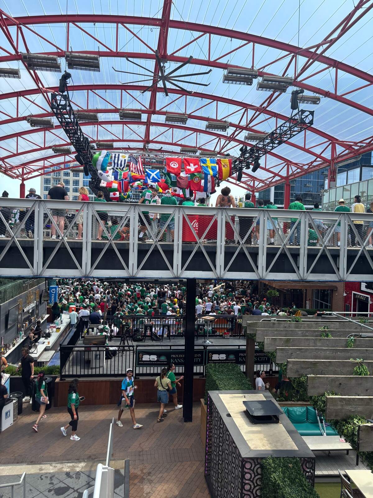 In the Power and Light District, fans mingle underneath flags of countries participating in the 2026 FIFA World Cup. June 11, 2026.