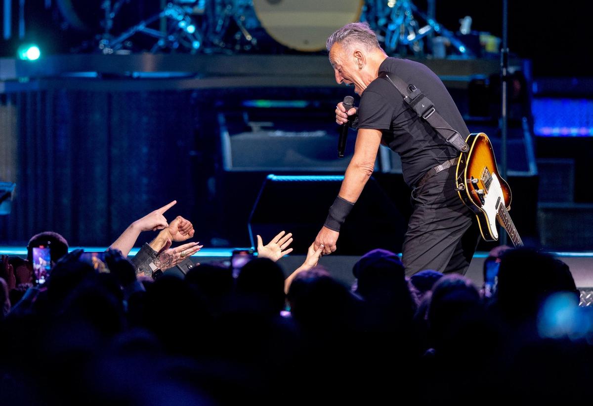 Bruce Springsteen grabs hold of a fan’s hand at T-Mobile Center on Saturday, Feb. 18, 2023, in Kansas City.