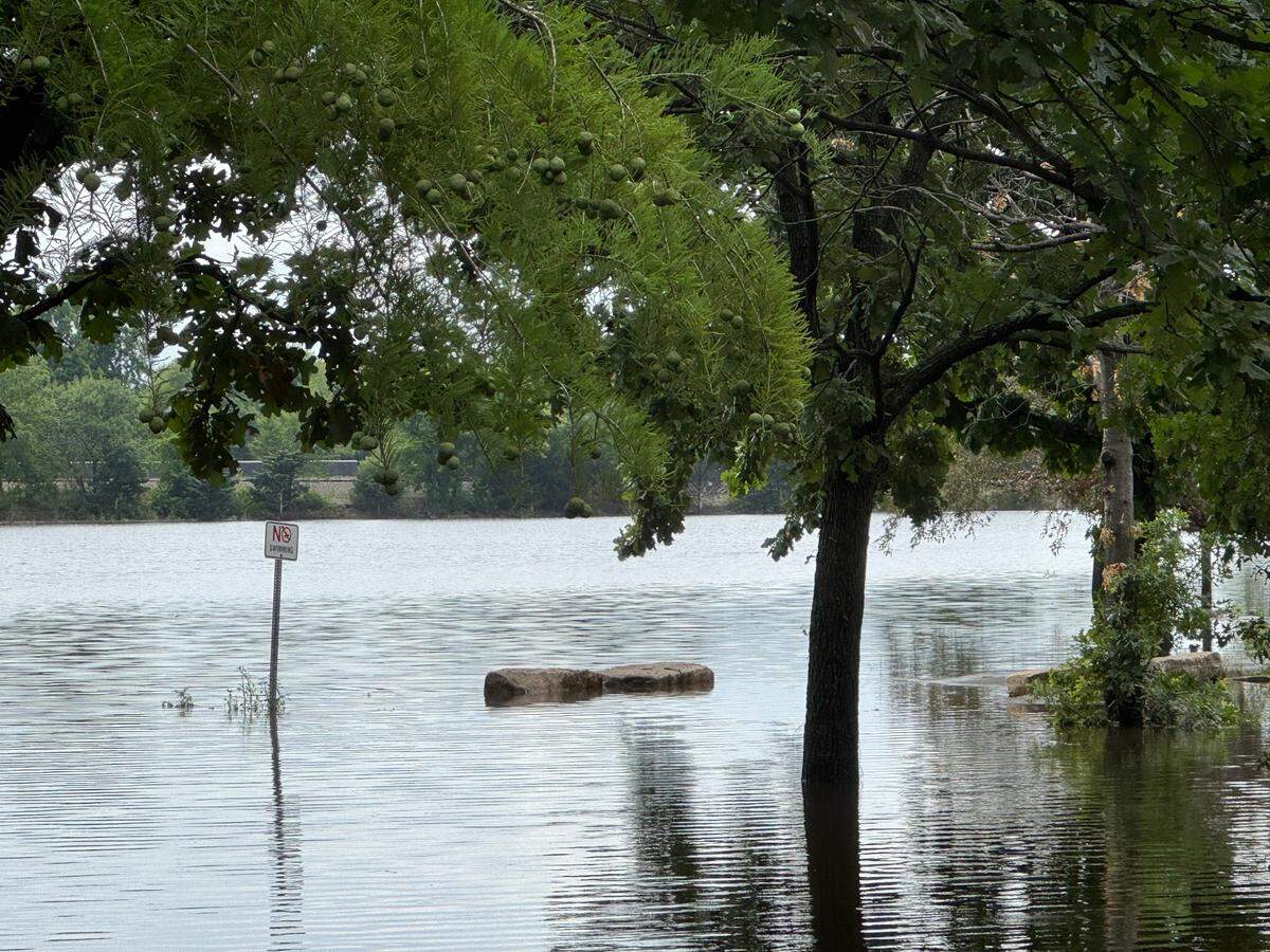 A "No Swimming" sign is surrounded in water. 