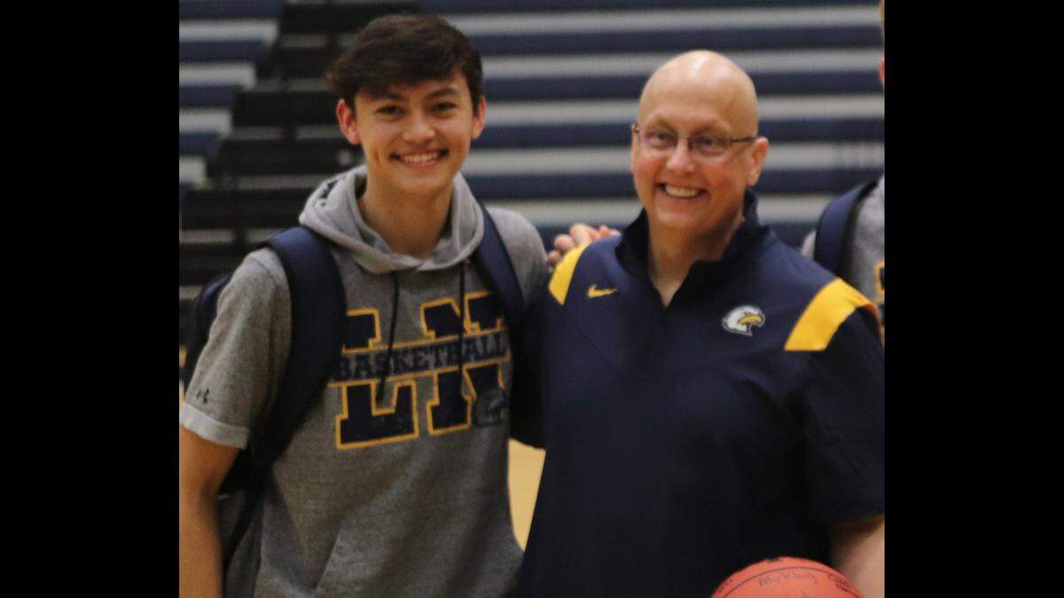 Liberty North assistant boys basketball coach Rob James and son Quinton James, a senior, pose for a photo in the school’s gymnasium.