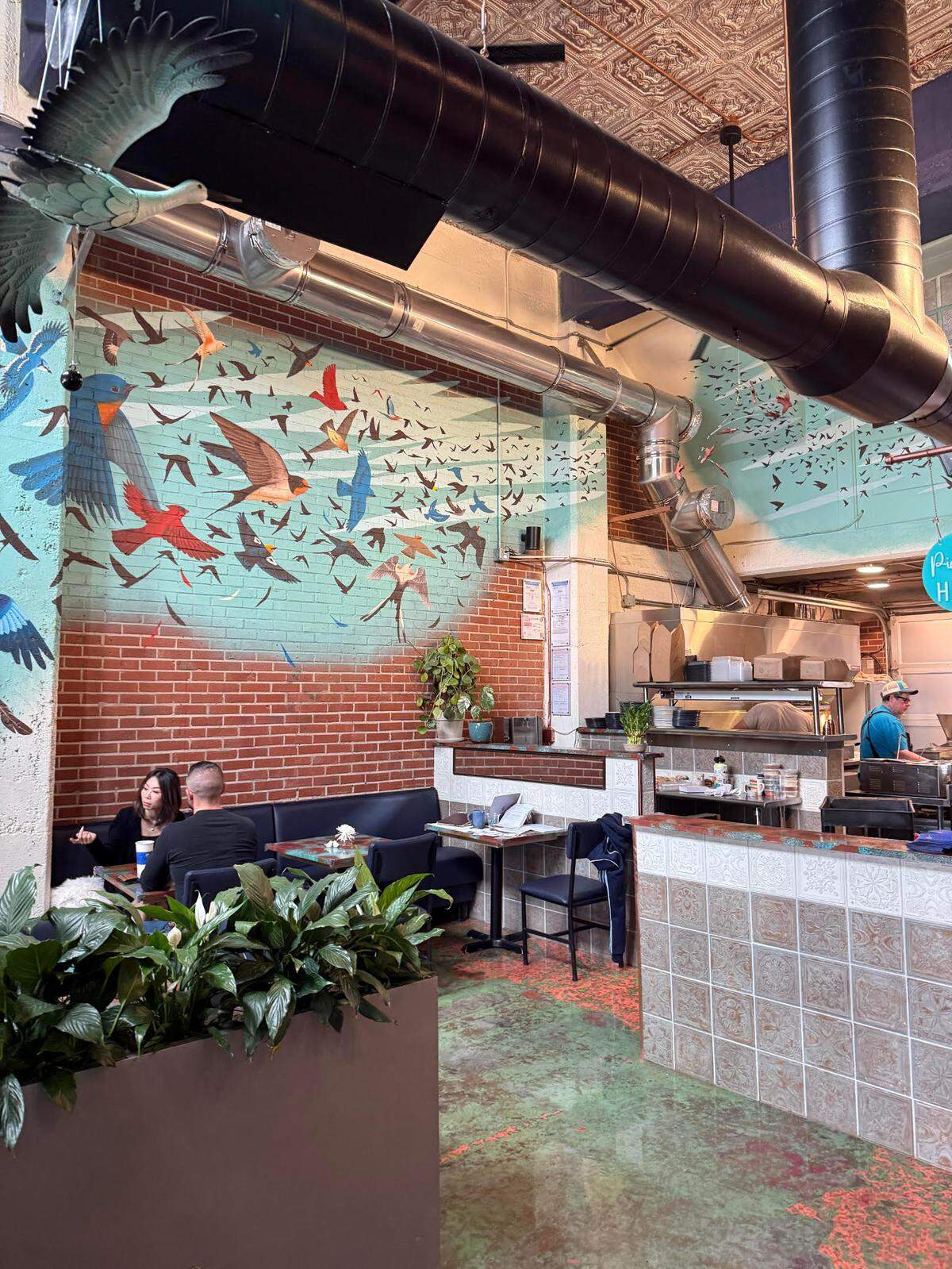 Birds fly up the side of Murmuration’s walls thanks to muralist Emily Alvarez.