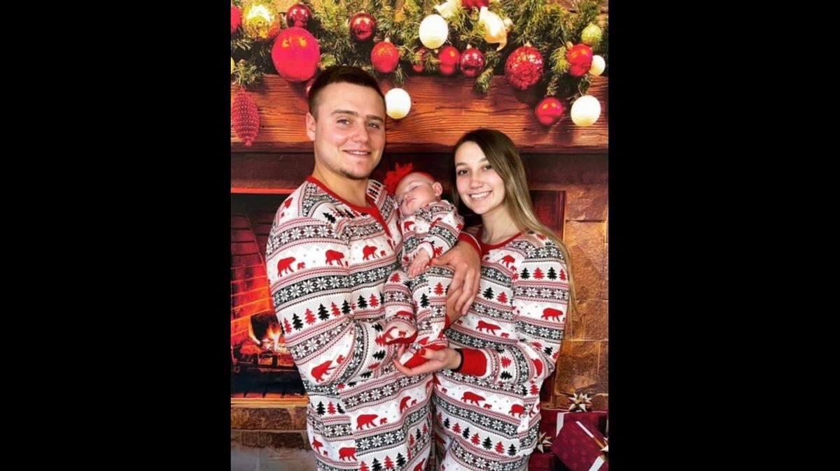 Riley Youngblood, 23, and Kali, 22, hold their newborn daughter for a Christmas photo in 2021.