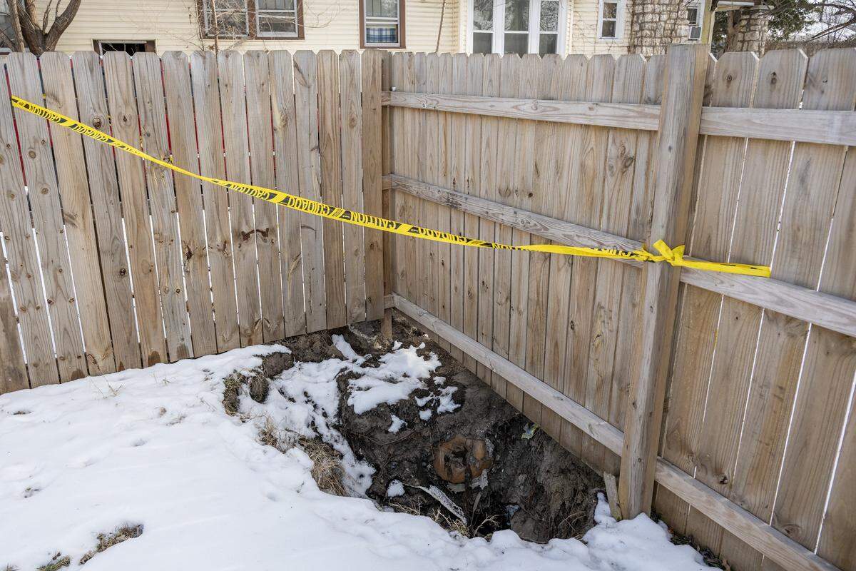 A sinkhole along a fence line in the backyard of Cassandra Krul's home is marked off with caution tape on Monday, Feb. 2, 2026, in Independence.