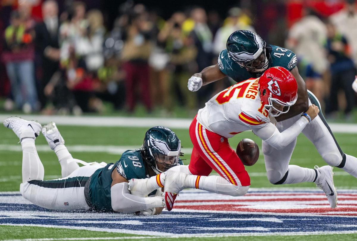 Kansas City Chiefs quarterback Patrick Mahomes (15) is tackled by Philadelphia Eagles linebacker Oren Burks (42) and Eagles defensive tackle Jalen Carter (98) in the second half of Super Bowl LIX on Sunday, Feb. 9, 2025, in New Orleans.