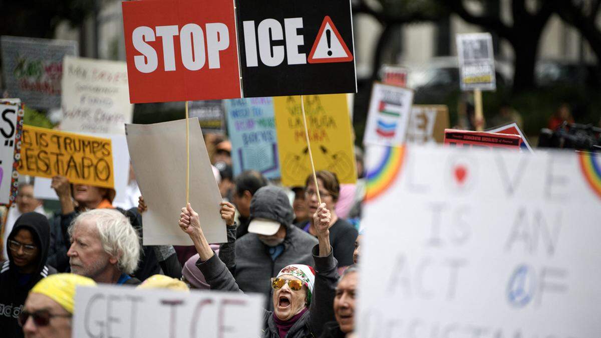 Demonstrators hold signs during a protest in Houston on Jan. 10.