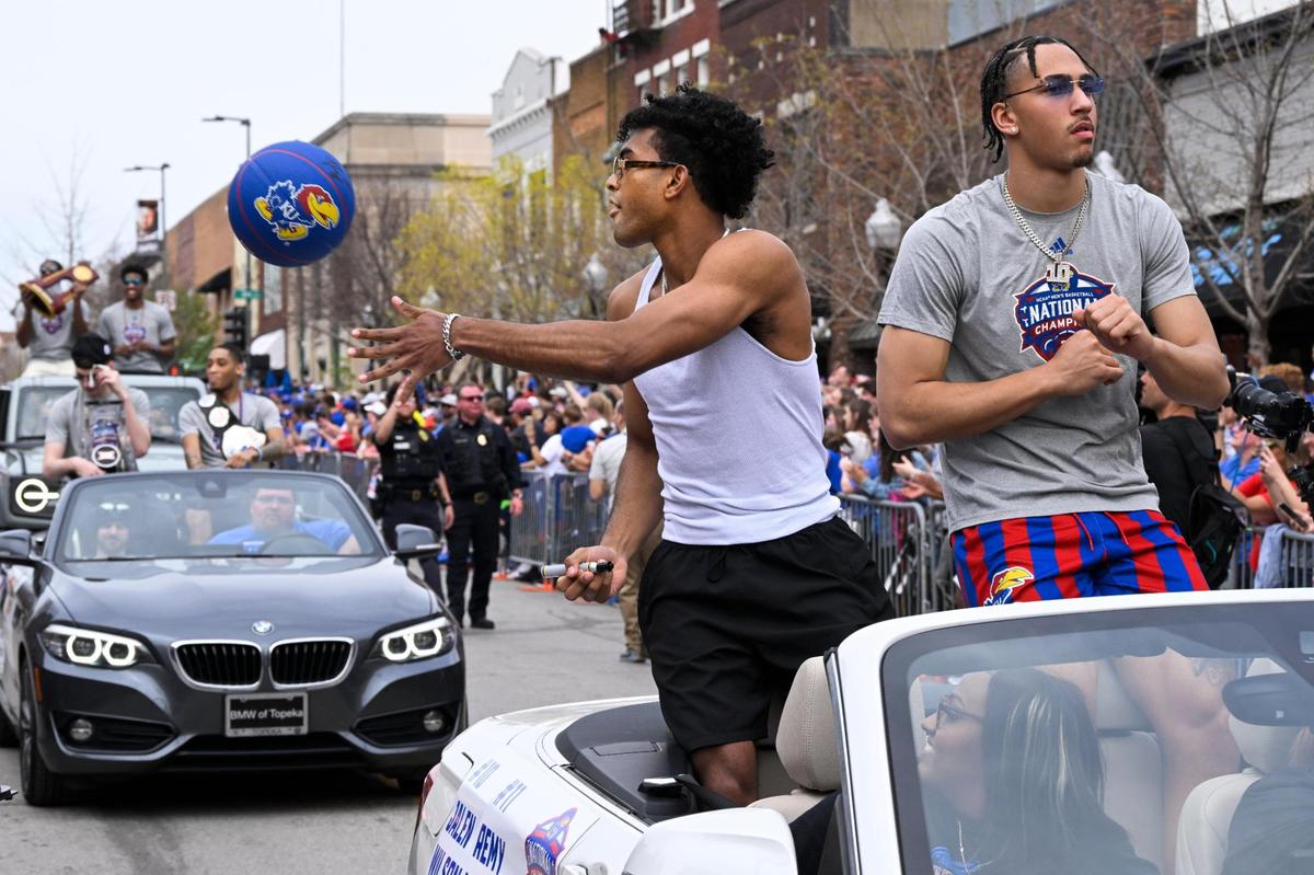 Remy Martin tosses an autographed ball to a fan as he and teammate Jalen Wilson ride in the Kansas Jayhawks NCAA Championship parade Sunday in Lawrence.