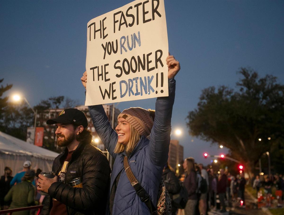 Jared and Makenzie Long of Chicago held up a sign to encourage friends Bryce Wright and Sadie and Cody Reeves during the 2024 Garmin Kansas City Marathon on Saturday, October 19, 2024 in KC.