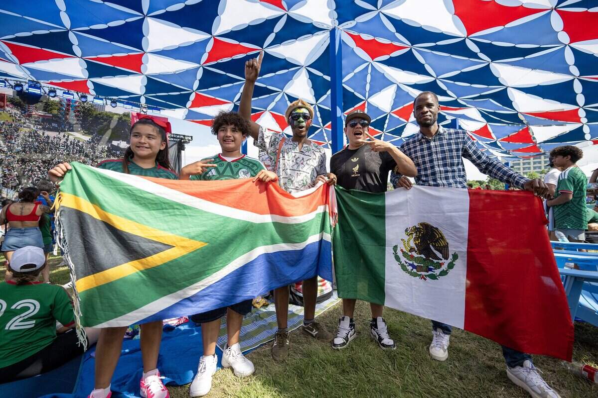 Sabelo Mthembu, center, a South Africa fan, cheers with Mexico fans at the FIFA Fan Festival after Mexico's 2-0 win over South Africa on Thursday, June 11, 2026, in Kansas City.