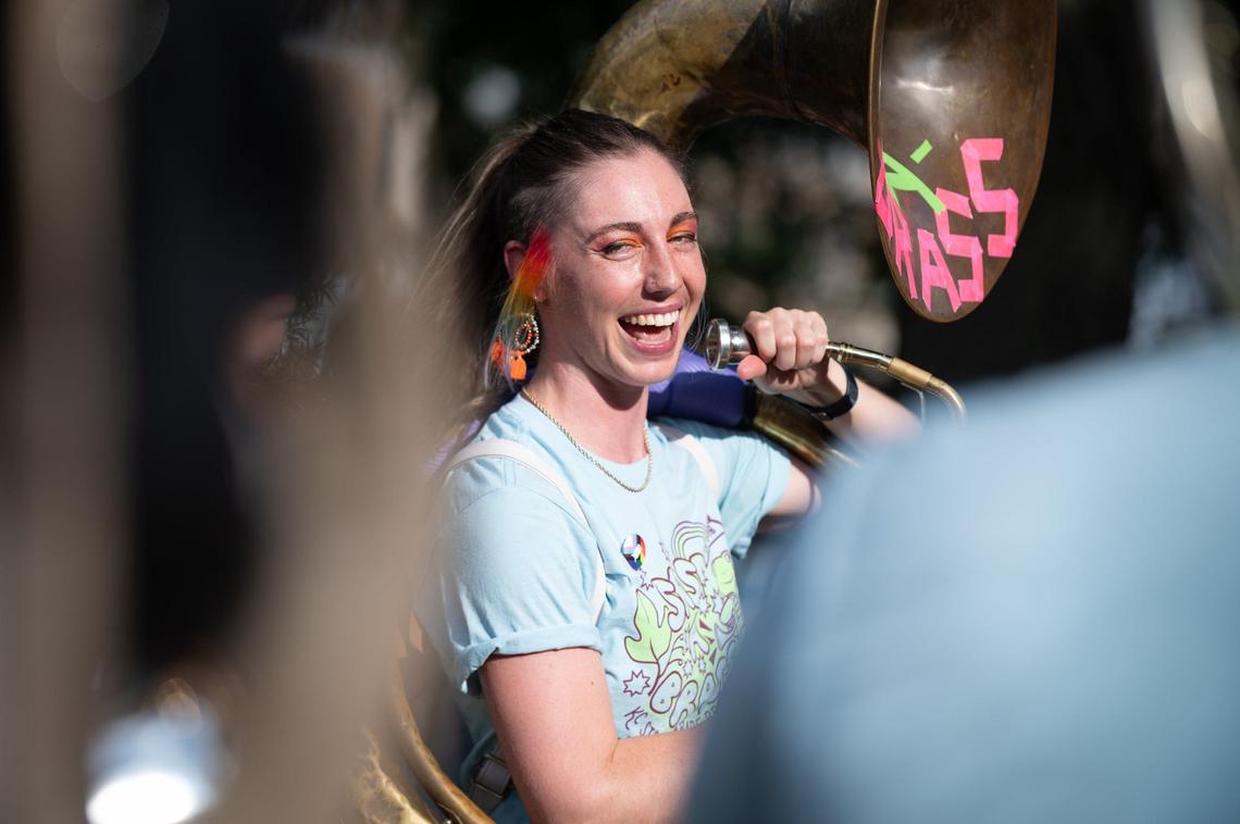 Sass-A-Brass band leader and sousaphonist Rosie O’Brien laughs with her bandmates during a break in a performance at the City Market Pride month celebration.