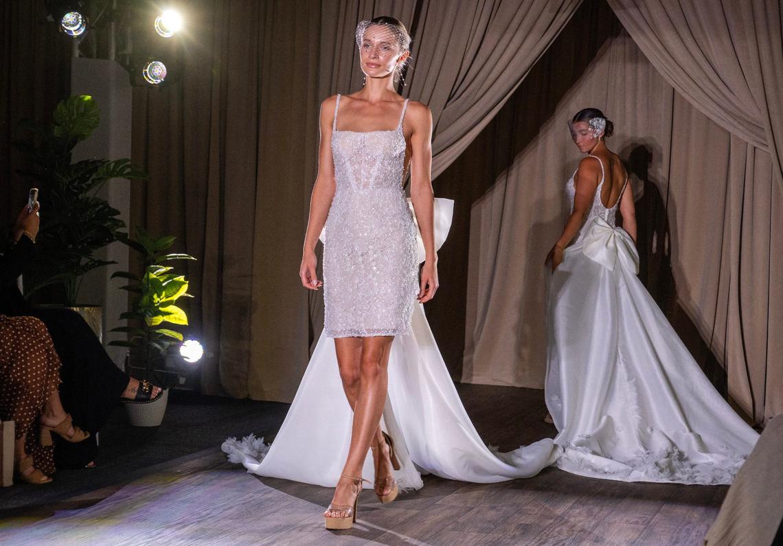 Models walk a runway showcasing a bridal dresses during a fashion show at Essense of Australia on Monday, Aug. 5, 2024, in Lenexa.