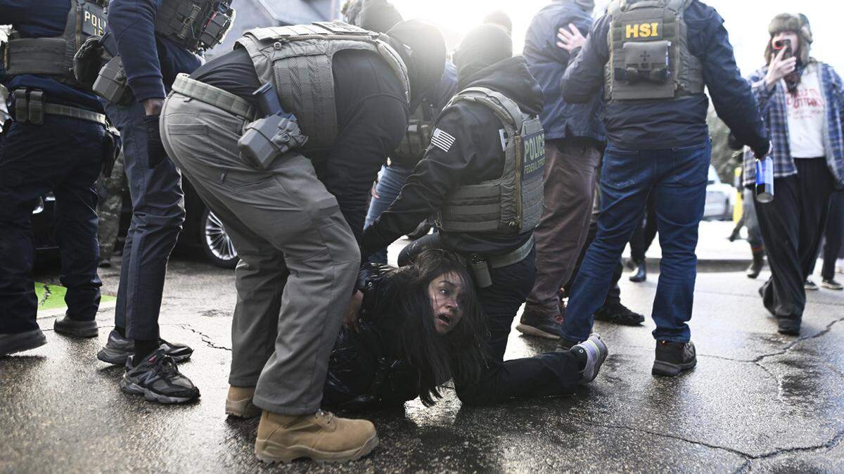 ICE agents detain a woman after pulling her from a car on January 13, 2026 in Minneapolis, Minnesota. The Trump administration has deployed over 2,400 Department of Homeland Security agents to the state of Minnesota in a push to apprehend undocumented immigrants. 