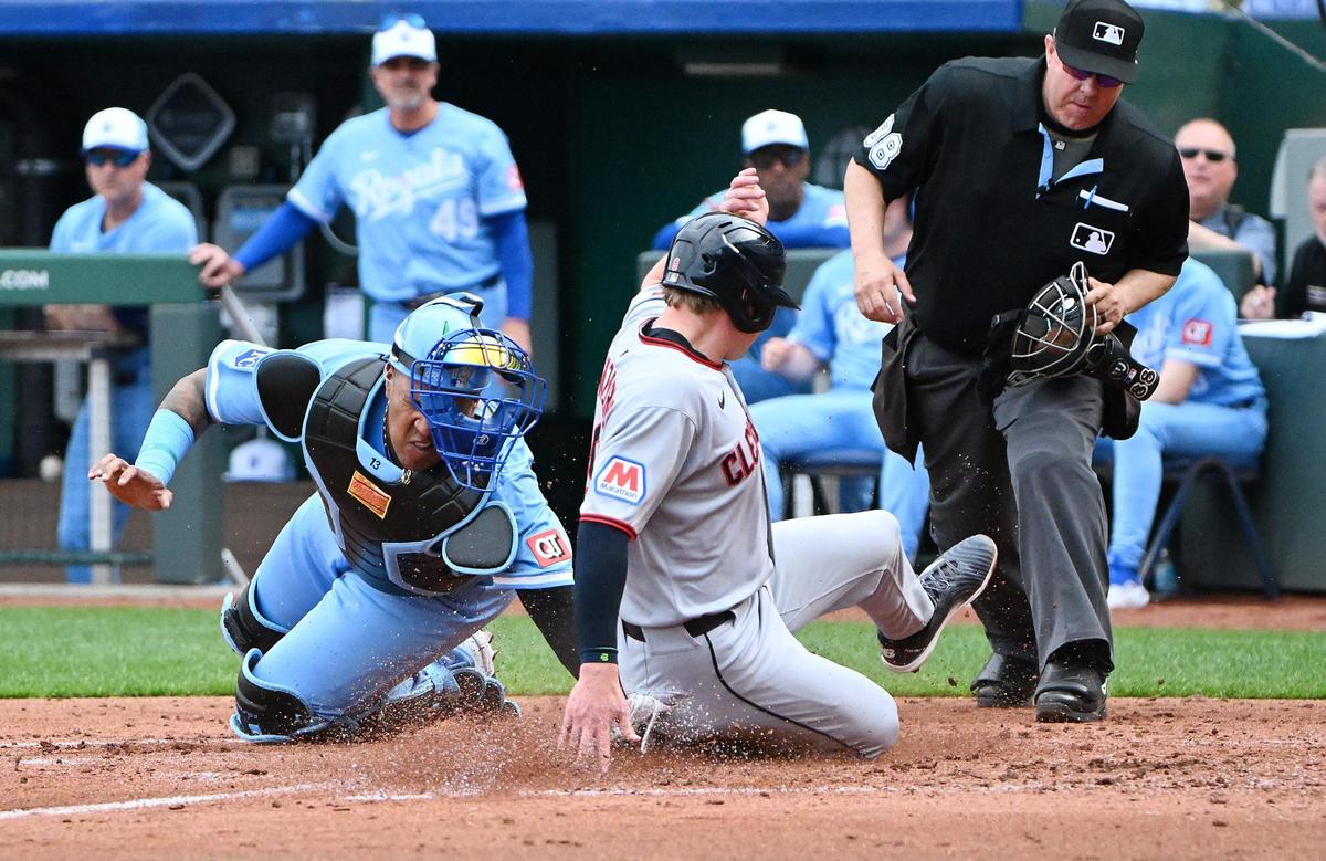 Kansas City Royals catcher Salvador Perez (13) couldn’t get the tag on Cleveland Guardians first baseman Kyle Manzardo (9) while he scored on a sacrifice fly in the 4th inning by Cleveland Guardians outfielder Jhonkensy Noel (43) during the opening day game Thursday, March 27, 2025, at Kauffman Stadium.