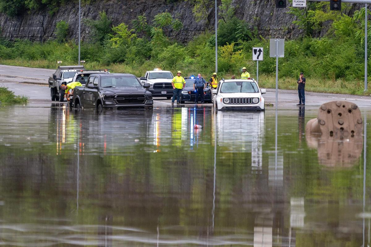 Emergency crews respond to stalled vehicles in floodwaters on East 23rd Street on Thursday, July 17, 2025, in Kansas City. Heavy overnight rain caused widespread flooding and road closures across the area.