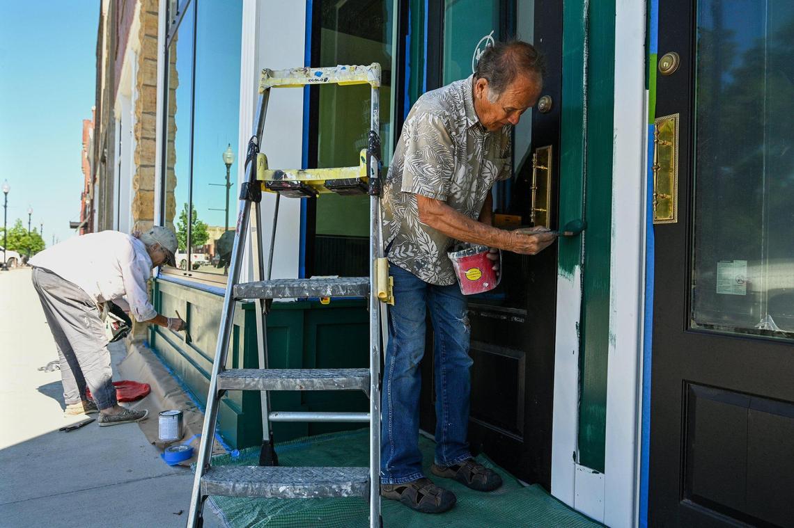 Diana Holmes and Joe Jackson paint the exterior of The Hitching Post, a space being renovated into a honky-tonk and whiskey bar by their son-in-law Paul Cloutier and daughter Alana.