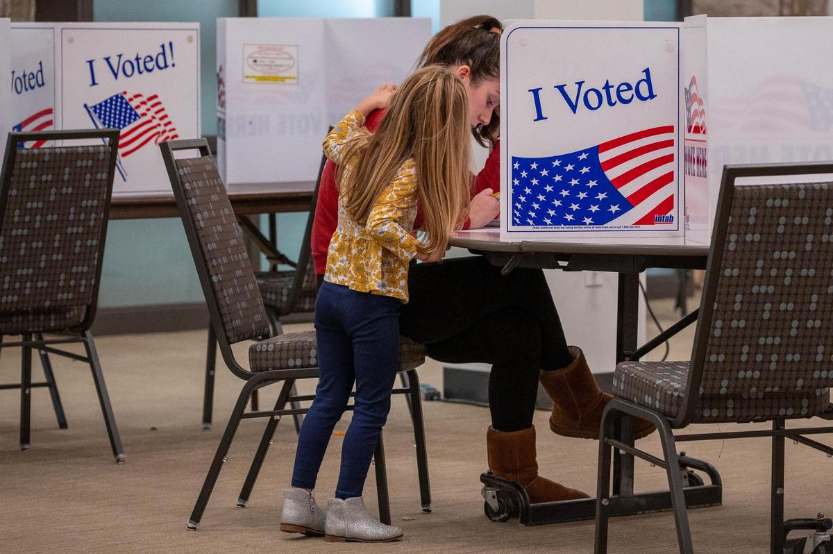Annie Murphy is comforted by her four-year-old daughter while casting her ballot for the general election at Country Club Christian Church on Tuesday, Nov. 5, 2024, in Kansas City.