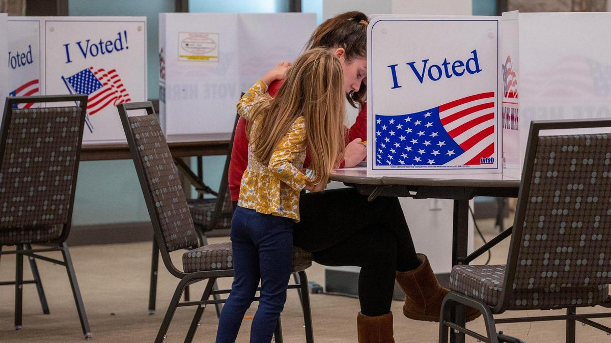 Annie Murphy is comforted by her four-year-old daughter while casting her ballot for the general election at Country Club Christian Church on Tuesday, Nov. 5, 2024, in Kansas City.
