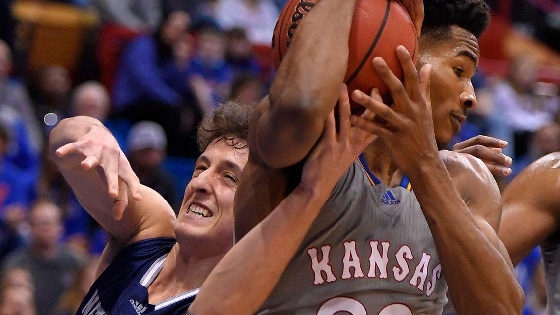 KU’s Ochai Agbaji grabs a rebound away from Nevanda’s Alem Huseinovic during the first half of Wednesday night’s game at Allen Fieldhouse.