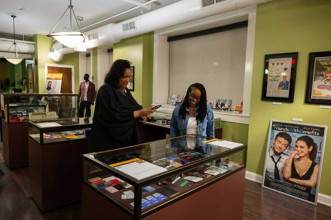 Two women look over several mementos from FOX4 film critic Shawn Edwards on display at the launch event for the Black Movie Hall of Fame, at the Black Archives of Mid-America, on Saturday, February 28, 2026. The Black Movie Hall of Fame with open in the newly renovated Boone Theater in the 18th and Vine Jazz District.