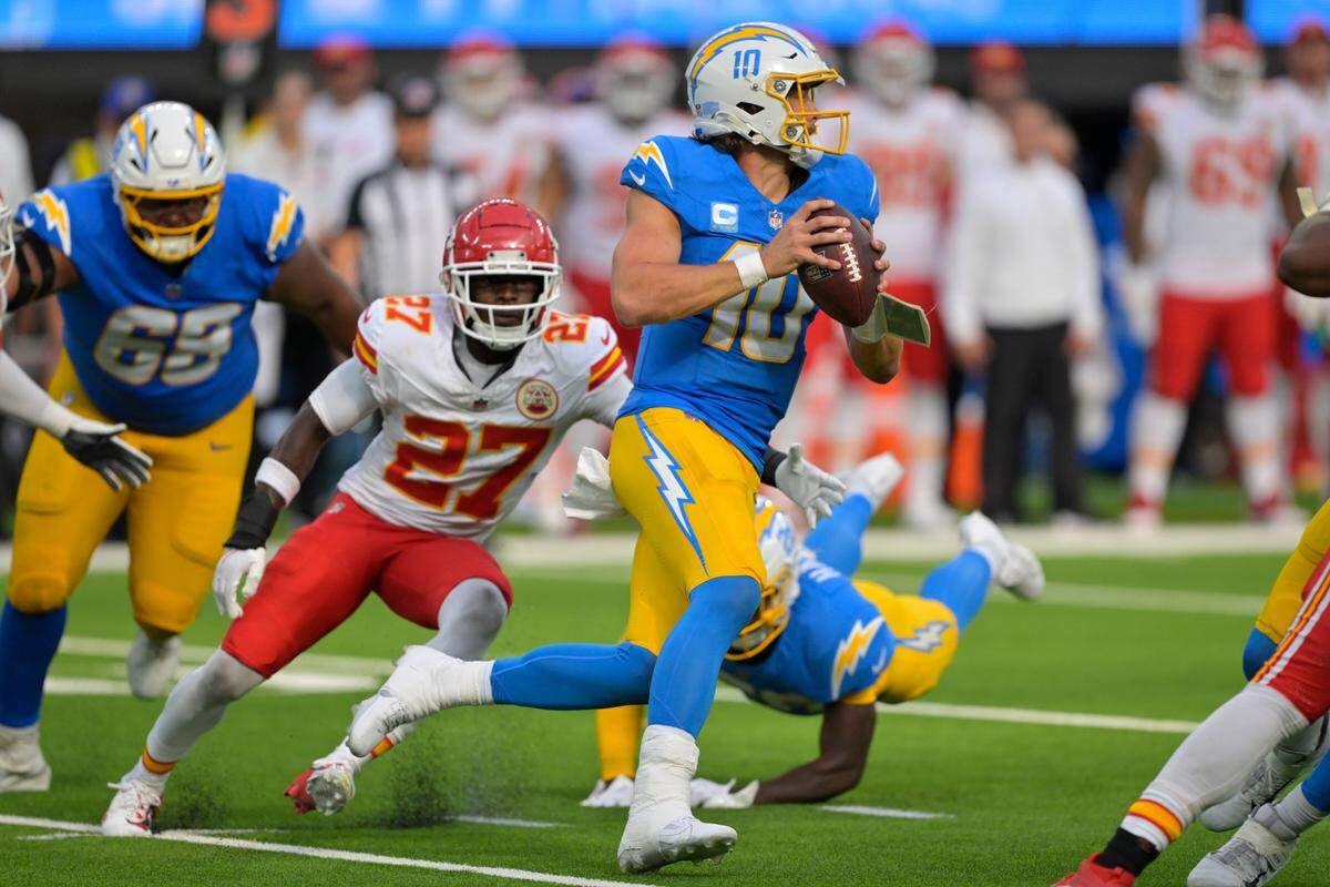 Los Angeles Chargers quarterback Justin Herbert (10) is pressured by Kansas City Chiefs safety Chamarri Conner (27) in the second half at SoFi Stadium.