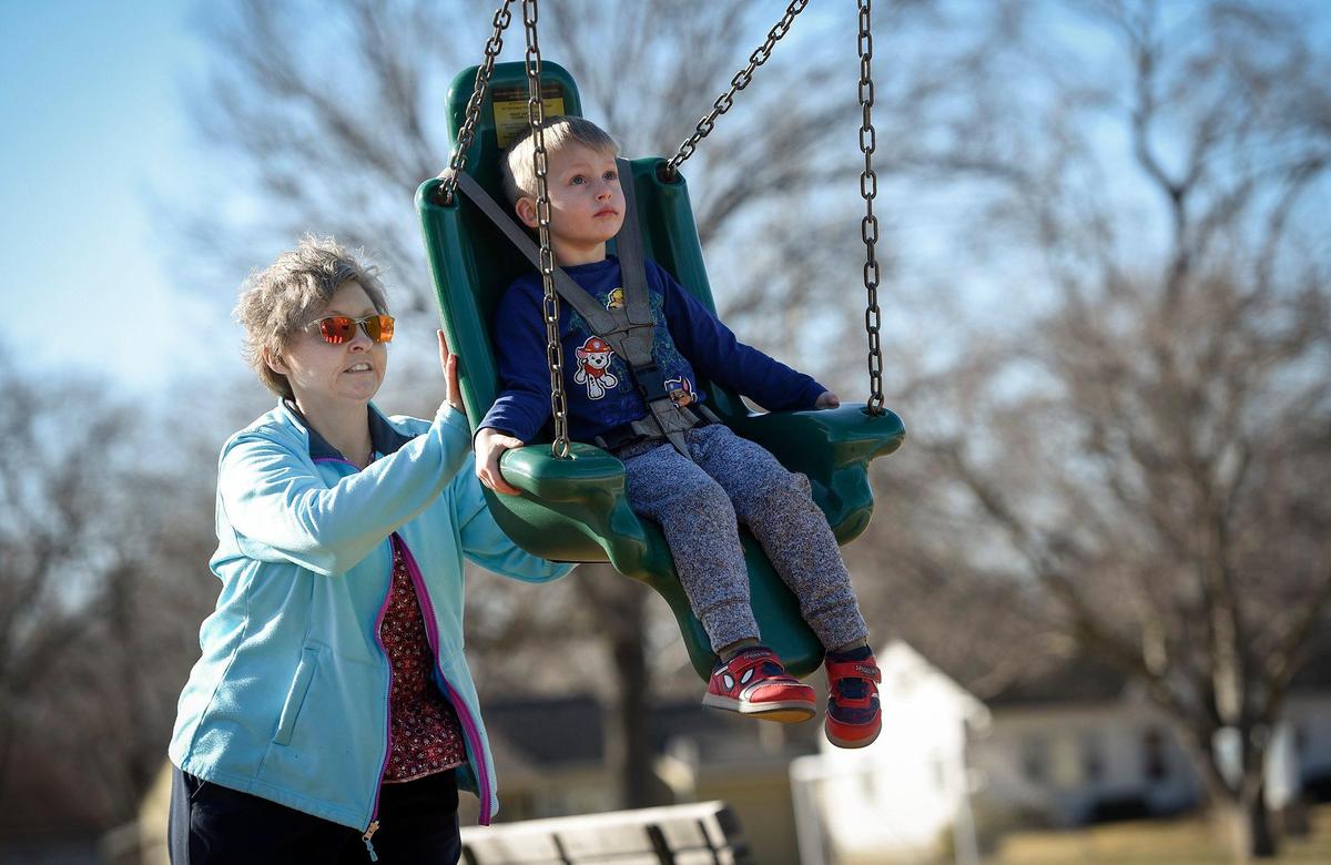 Angie Grady of Mission, pushes her grandson Troy Becker, 4, in a swing at R Park in Roeland Park. Grady said her home in Mission has seen a $100,000 increase in appraised value in six years, meaning her taxes rise every year. If it weren’t for family, she said, she and her husband might consider moving out of Johnson County.