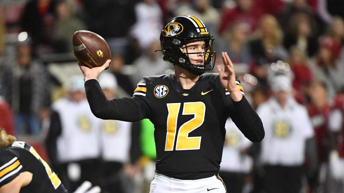 Missouri quarterback Brady Cook (12) throws the ball against Arkansas during an NCAA college football game Friday, Nov. 26, 2021, in Fayetteville, Ark. (AP Photo/Michael Woods)