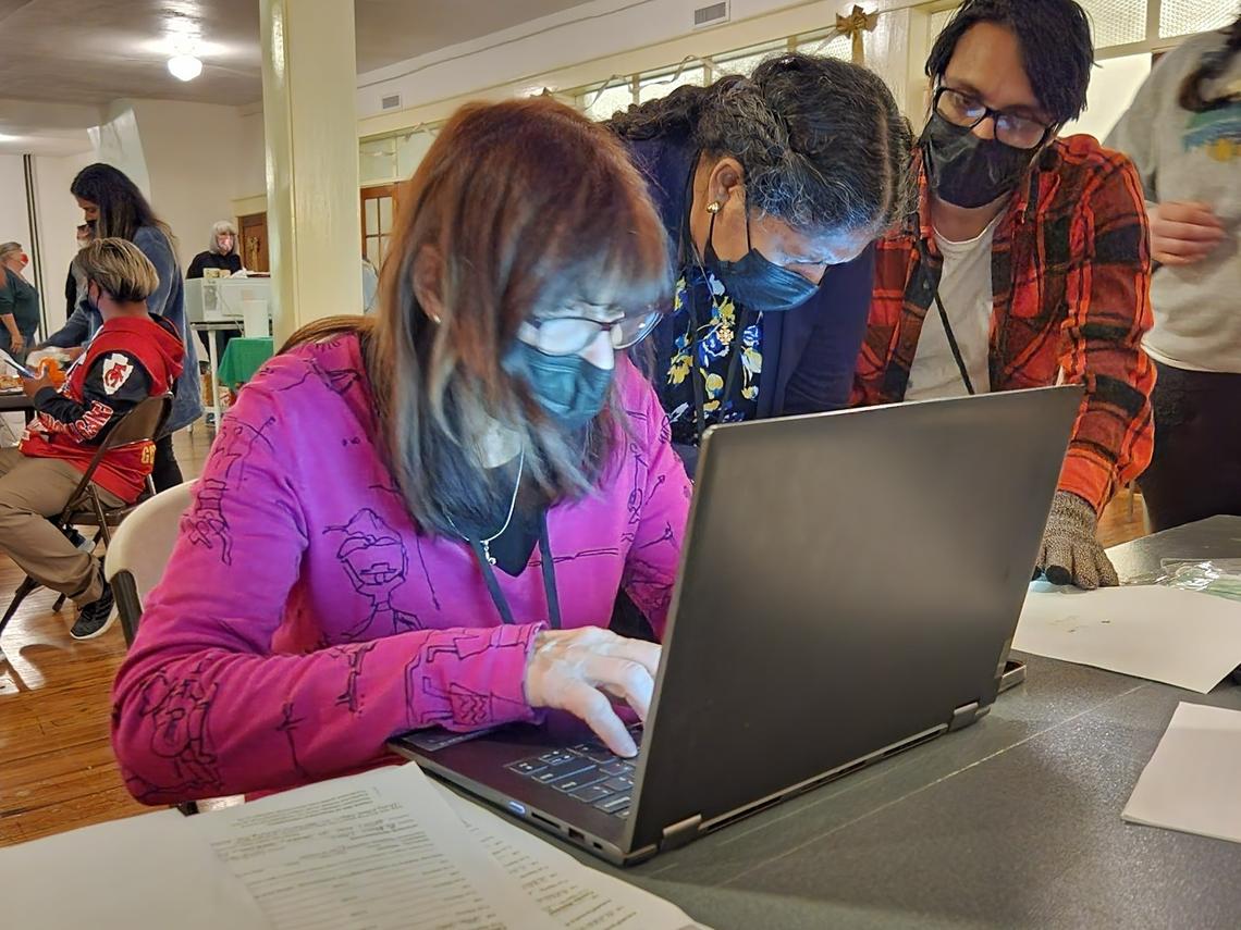 Volunteers working with asylum seekers at a local church work to connect families with flights out of the state, to be reunited with their sponsors.