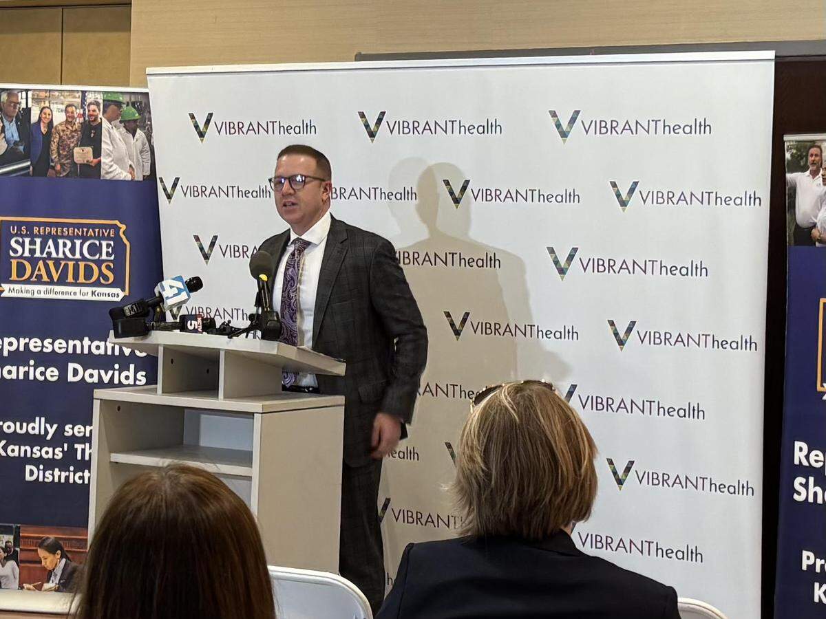 Patrick Sallee, president and CEO of Vibrant Health, speaks against possible cuts to Medicaid at an event with Rep. Sharice Davids, a Kansas Democrat.