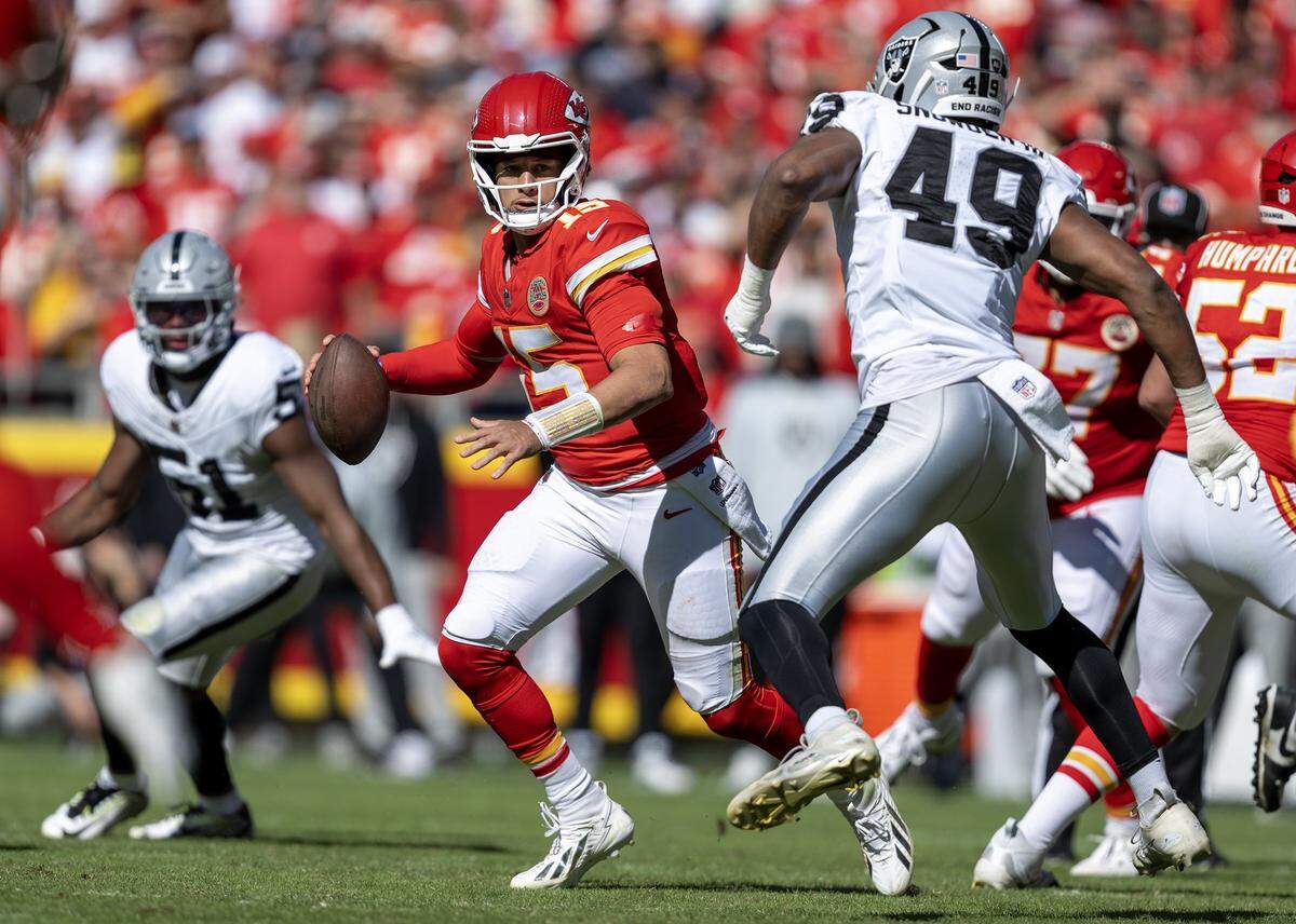 Kansas City Chiefs quarterback Patrick Mahomes (15) is pressured by Las Vegas Raiders defensive end Charles Snowden (49) during the second half on Sunday, October 19, 2025, at GEHA Field at Arrowhead Stadium in Kansas City. The Chiefs defeated the Raiders, 31-0.