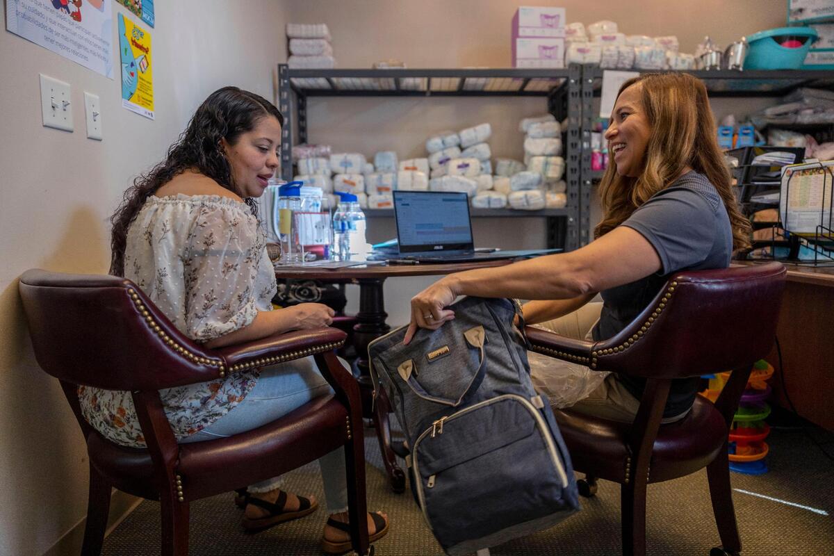 Marcela Metcalf, a lead community health worker at Nurture KC, gives a diaper bag to Fabiola Irias, who recently moved to the Unites States. Irias said she’s never felt so supported in a pregnancy before.