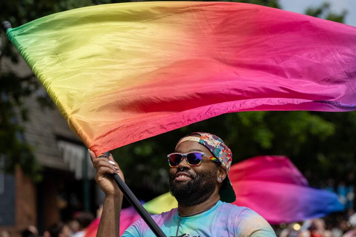 Stephen Irving, member of the Mid America Freedom Band Kansas City Color guard spins their flag as they walk in the Annual Pride Parade at Westport Rd on Saturday, June 6, 2026.