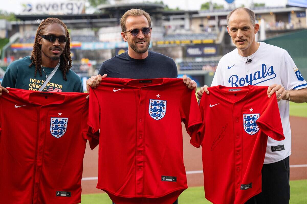 England national soccer team players Djed Spence, Harry Kane, and team manager Thomas Tuchel, hold custom "Three Lions" baseball jerseys before the Royals game vs. the St. Louis Cardinals, at Kauffman Stadium on Thursday, June 18, 2026.
