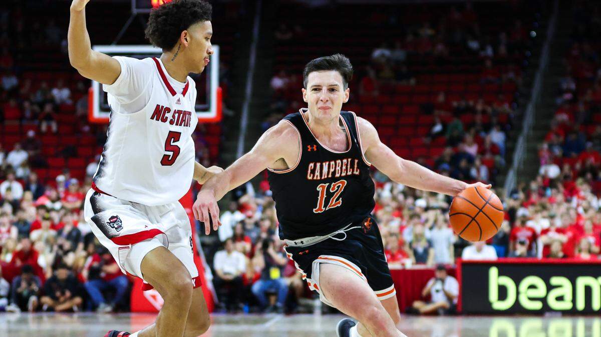 Campbell forward Jesus Carralero (12) dribbles against North Carolina State at PNC Arena in Raleigh, North Carolina, on Nov. 11, 2022.
