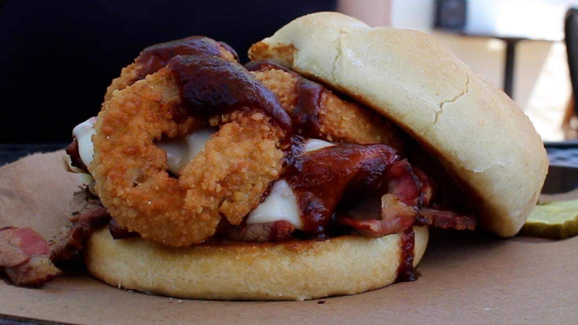 The Z-Man sandwich at Joe's Kansas City Bar-B-Que is a brisket sandwich topped with provolone cheese, onion rings and barbecue sauce.