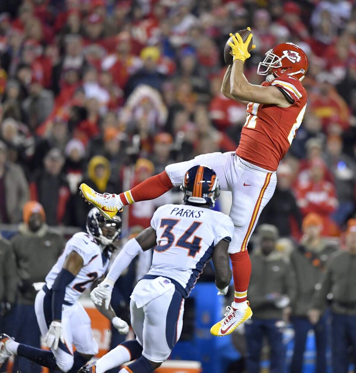 Travis Kelce catches a pass for a first down over Denver Broncos defensive back Will Parks during a Monday night game on October 30, 2017, at Arrowhead Stadium.