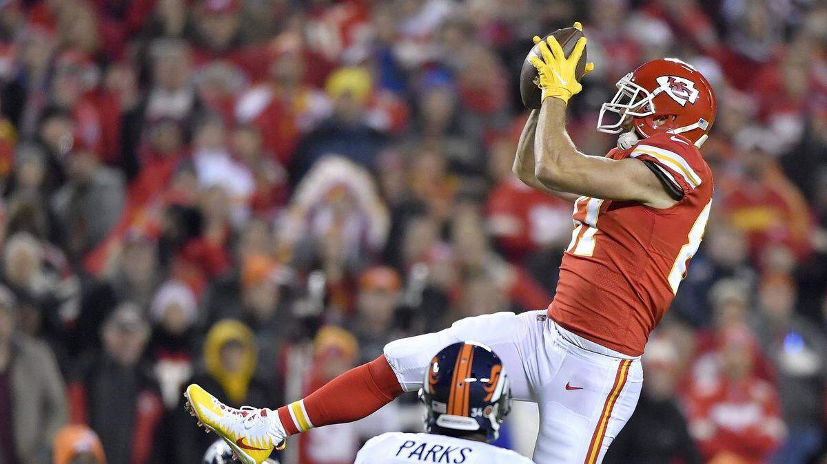 Travis Kelce catches a first down pass over Denver Broncos defensive back Will Parks during a Monday night game on October 30, 2017, at Arrowhead Stadium.