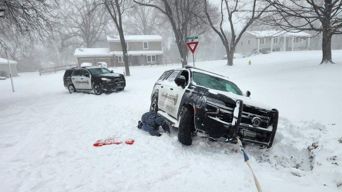 An Olathe Police Department vehicle is seen stuck on the side of the road in a residential area on Sunday, Jan. 5, 2025. Law enforcement advises against travel Monday as road conditions remain dangerous.