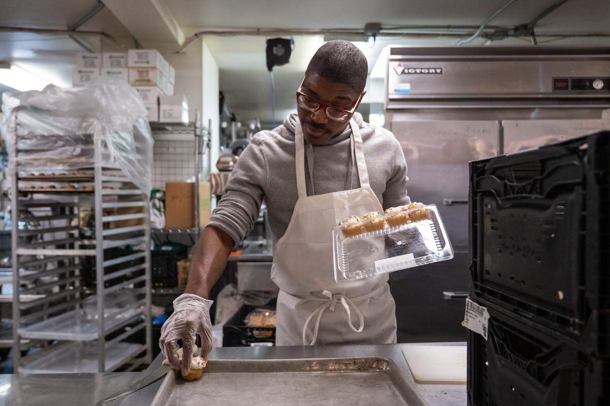 Volunteer Tyler Bonwell prepares desserts at Nourish KC, a community kitchen, on Thursday, November 6, 2025, in Kansas City. Homeless customers are able to come and eat a hot meal complete with service and a free pantry.