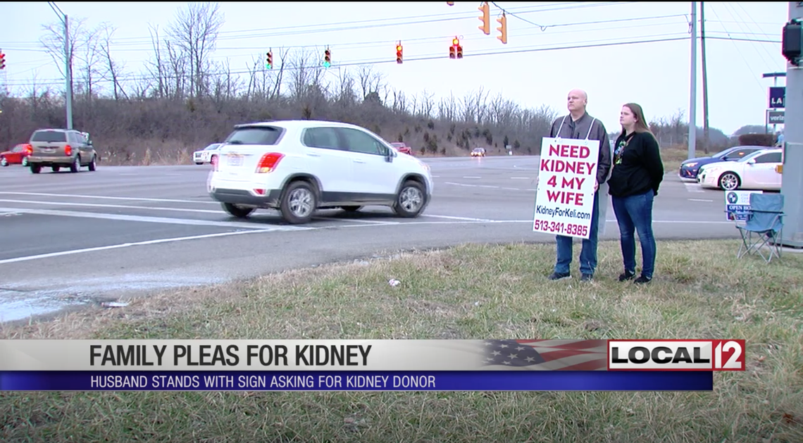 Aaron Thorn stands on an Ohio intersection with a sign as he tries to find a kidney donor for his wife.