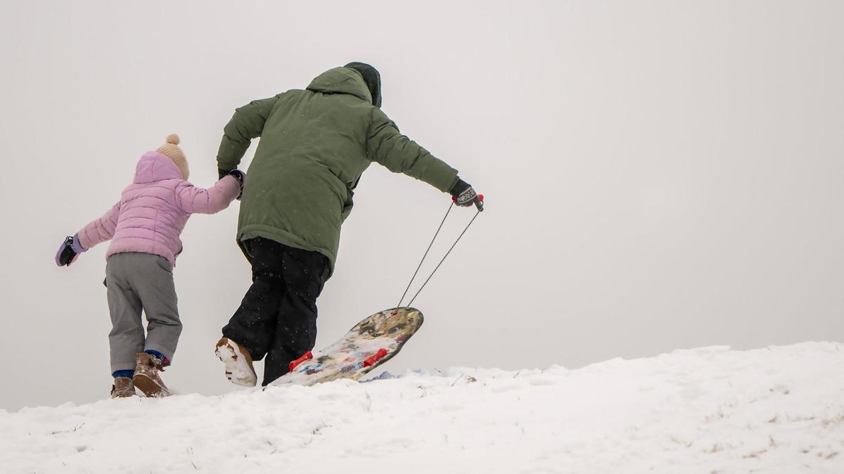 A little sledder needed some help to get back up the hill at Meadowbrook Park in Prairie Village on Wednesday, Feb. 12, 2025.