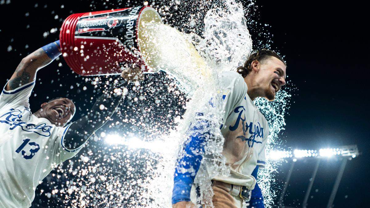 Kansas City Royals shortstop Bobby Witt Jr. (7) is doused with water by catcher Salvador Perez (13) after defeating the Arizona Diamondbacks at Kauffman Stadium on July 22, 2024.