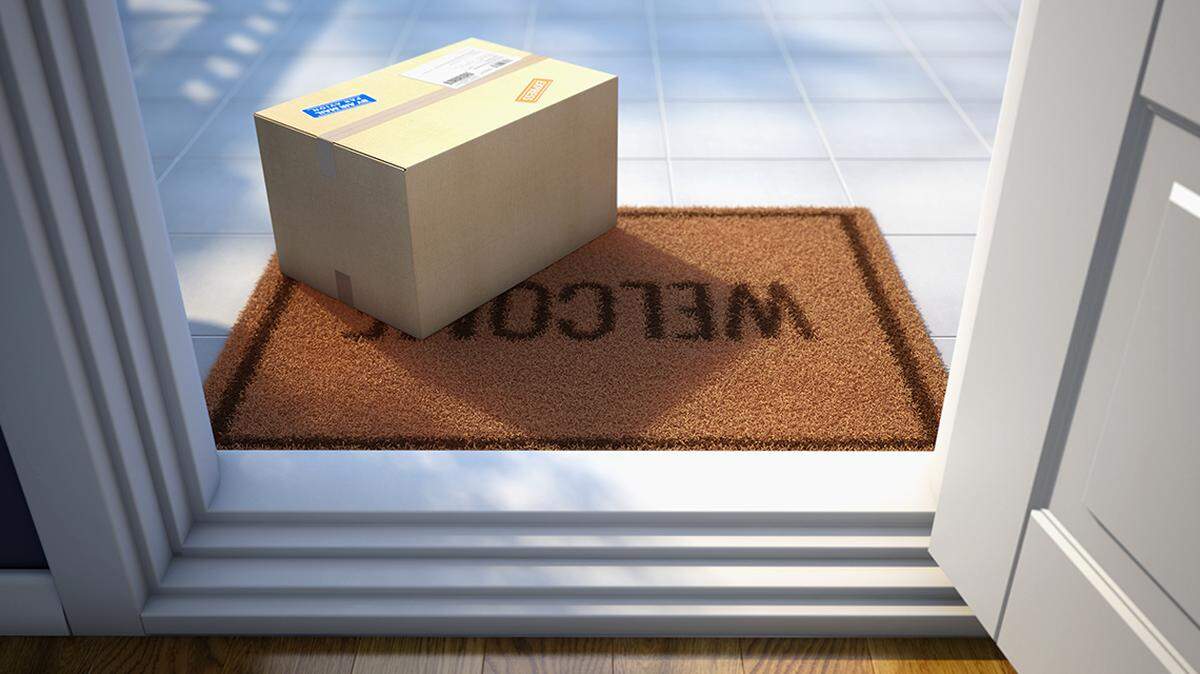 Cardboard parcel box delivered outside the door. Parcel on the door mat near entrance door. Online purchase delivery concept. 3d rendering