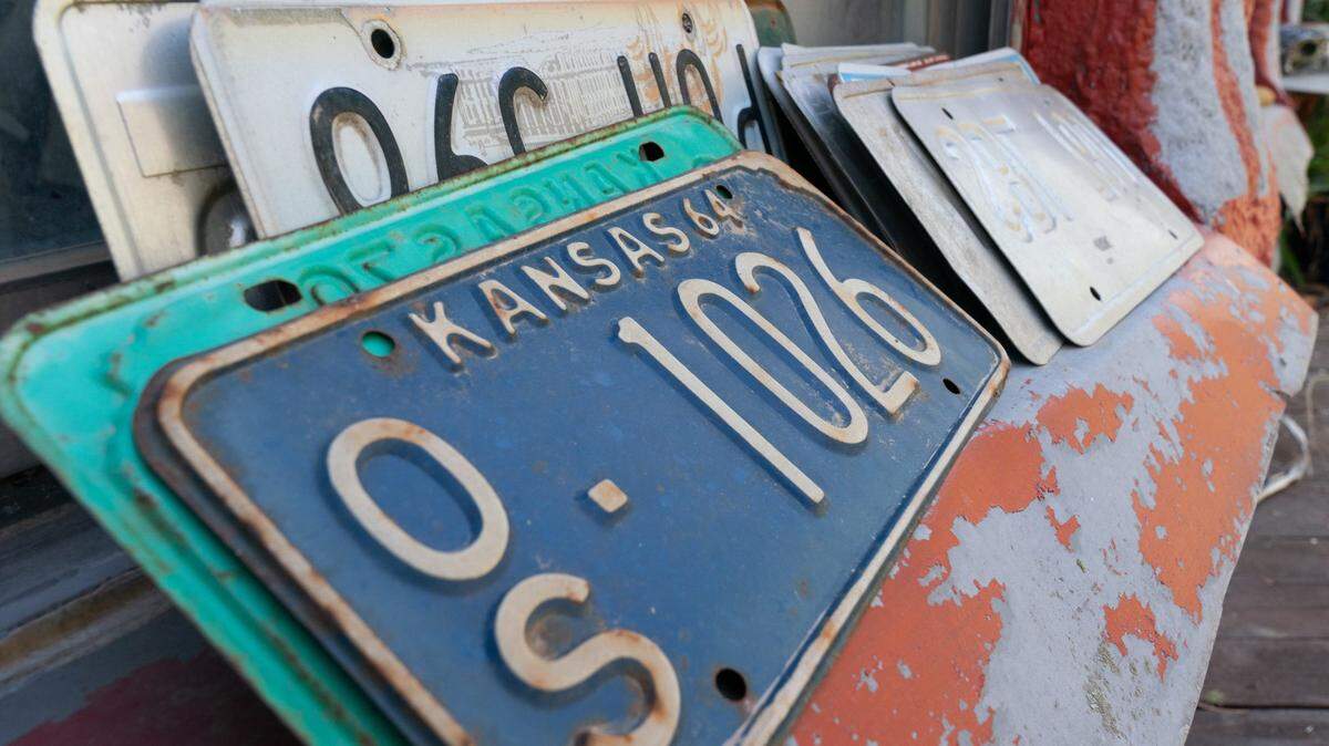 A collection of old Kansas license plates with embossed lettering are seen on a windowsill at the Truckhenge property in east Topeka.