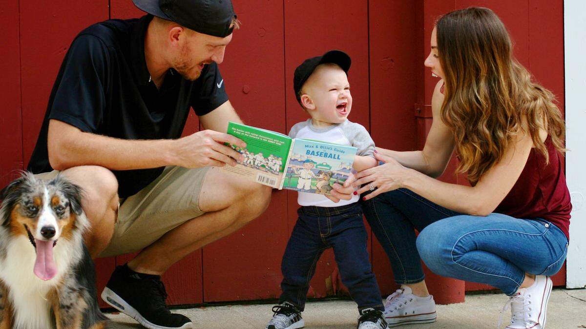 Royals pitcher Mike Montgomery, left, and author and Mike’s wife, Stephanie Montgomery, right, play with son Max. At left is the other star of Stephanie’s new book, Ollie.