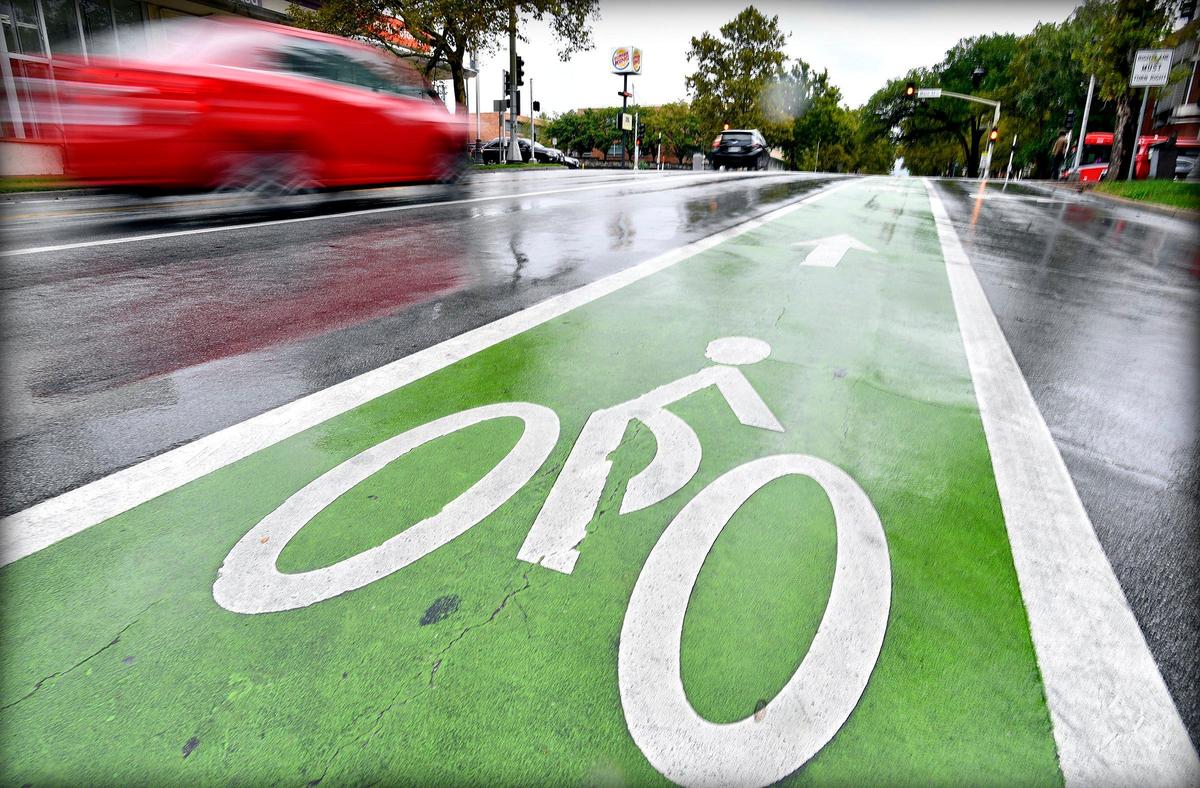 A bike lane is part of the intersection at Armour Boulevard and Main Street in Midtown. Proponents maintain bicycling can save cities on the costs of road construction and maintenance.