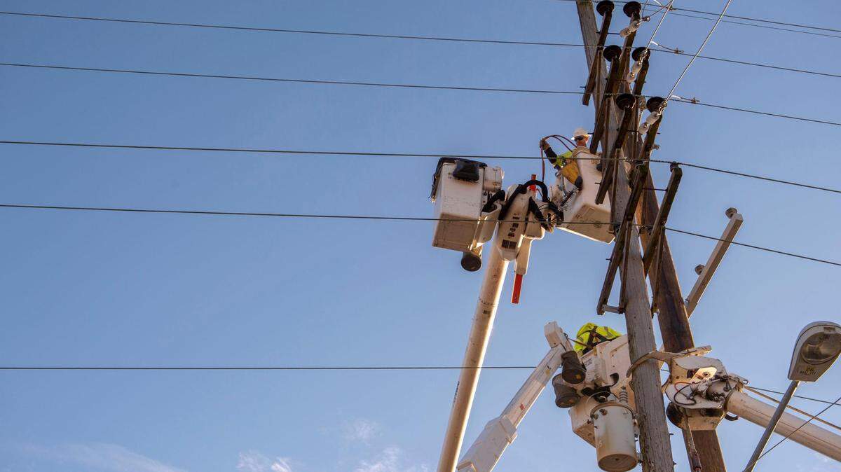 Evergy crew members repair a damaged electricity pole on West 25th Street in Kansas City on Thursday, Dec. 16, 2021. The damage comes a day after Kansas City experienced a severe thunderstorm and high winds.