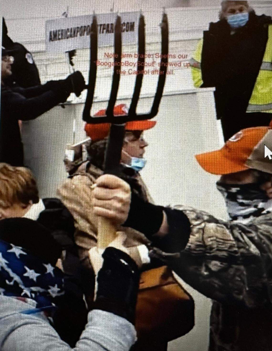 Federal prosecutors say this is Christopher Roe holding a pitchfork and standing a few feet from the police line outside the U.S. Capitol on Jan. 6, 2021.
